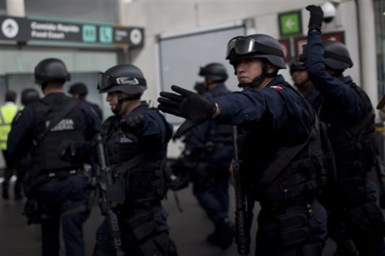 Mexico's Federal Police officers arrive at Mexico City's international airport, where three officers were killed in a shoot-out. 